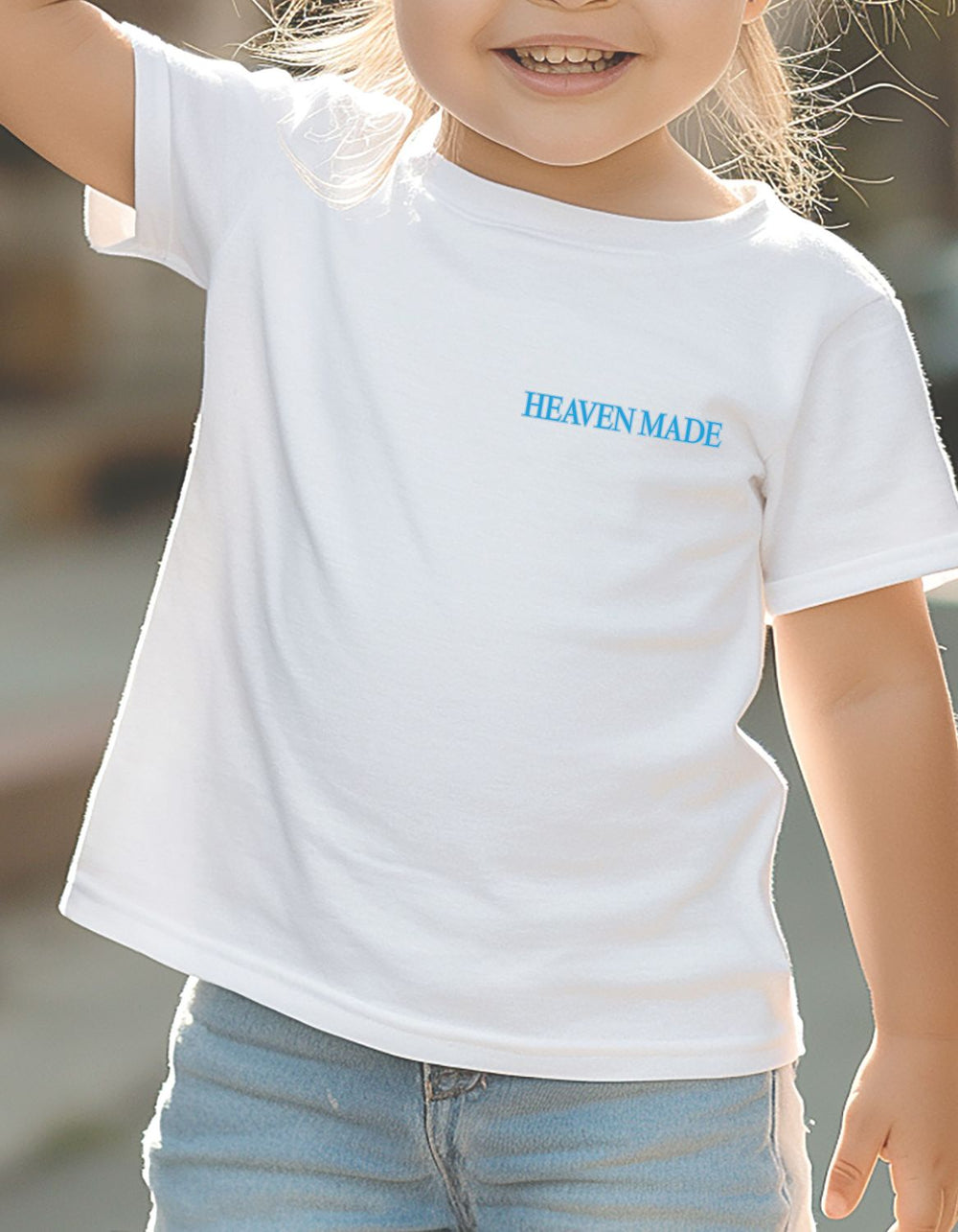 Toddler wearing Heaven Made white tee from Faith Family Designs, showcasing eco-friendly style with a classic fit and soft cotton comfort.