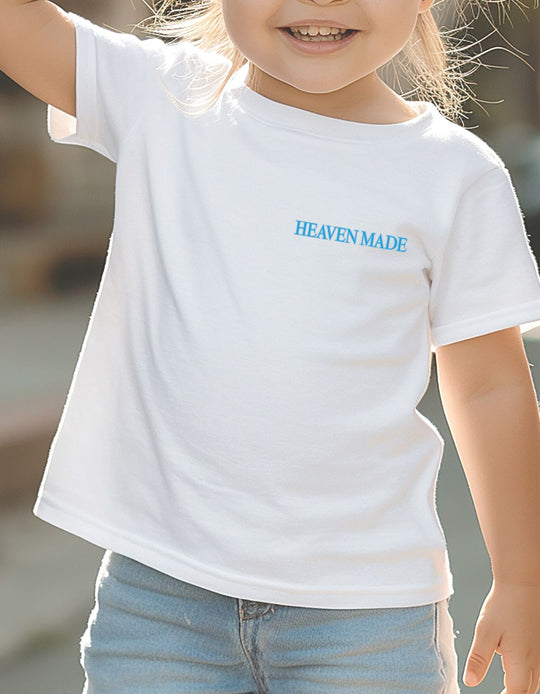 Toddler wearing Heaven Made white tee from Faith Family Designs, showcasing eco-friendly style with a classic fit and soft cotton comfort.