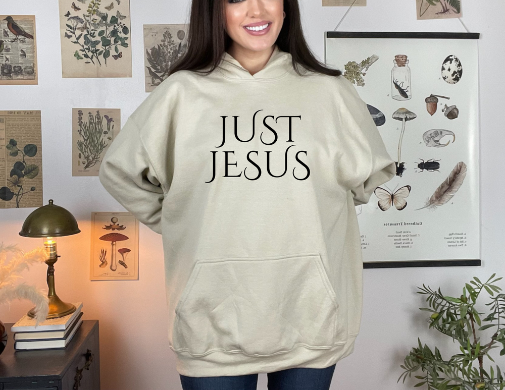 A heavy blend Just Jesus Hoodie in cotton and polyester, with a kangaroo pocket, no side seams, and a color-matching drawstring. Classic fit, tear-away label, medium-heavy fabric.