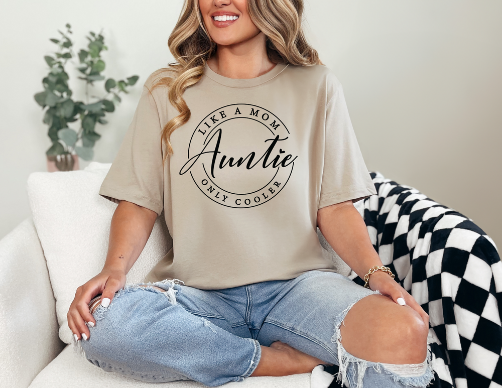 Woman on couch wearing the Auntie Tee, a unisex heavy cotton t-shirt, showcasing its classic fit and smooth fabric for premium printing.