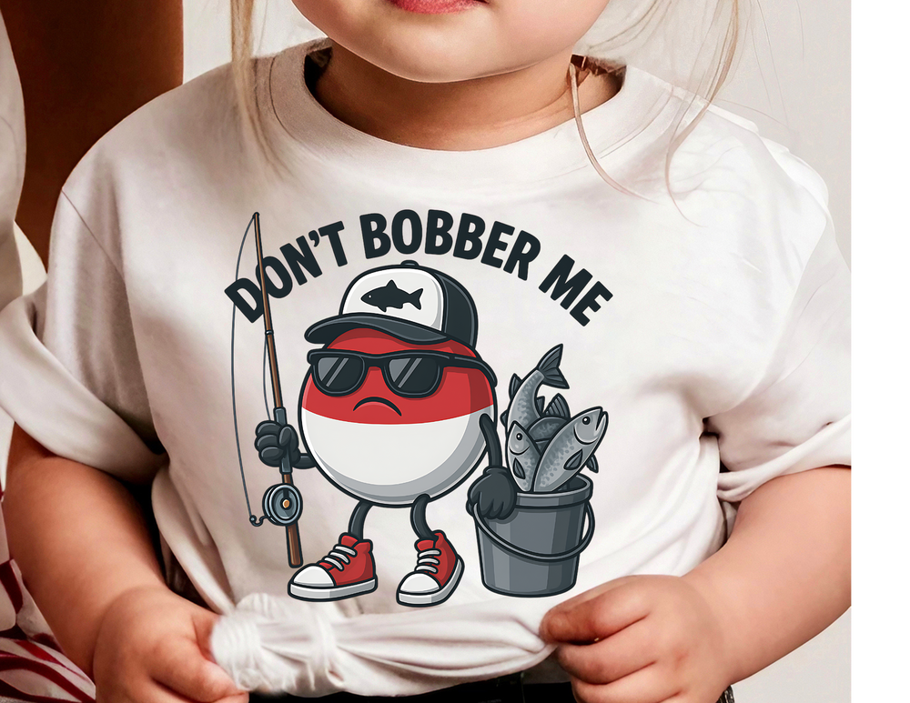 Child wearing Don't Bobber Me Kids Tee, featuring a cartoon bobber with sunglasses, baseball cap, fishing rod, and fish-filled pail, perfect for everyday wear.