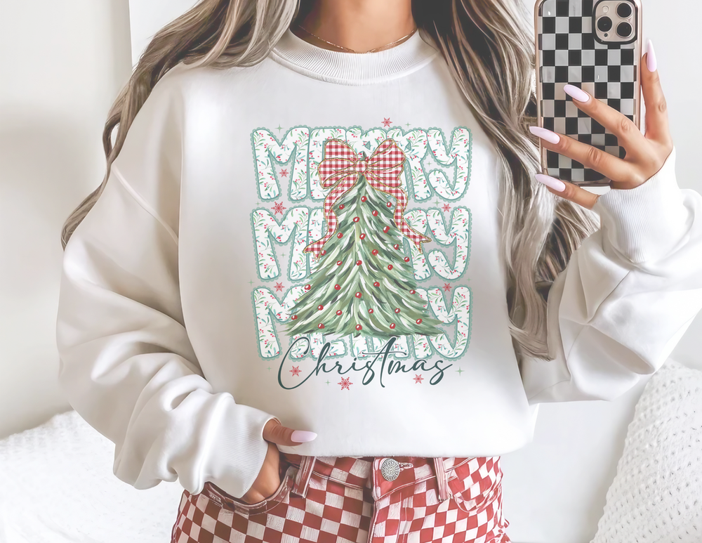 Person wearing Merry Merry Merry Christmas Crew sweatshirt with a stylized tree design, paired with red-and-white checkerboard pants, capturing a trendy holiday outfit in a mirror selfie.