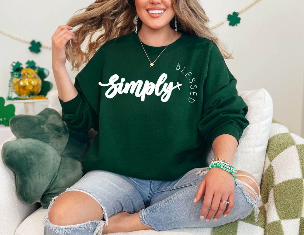 Woman on a couch wearing the Simply Blessed Crew sweatshirt, showcasing a comfortable, unisex design with ribbed knit collar, perfect for casual settings.