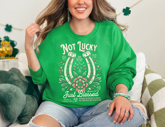 Woman smiling on a couch, wearing the Blessed Crew unisex heavy blend crewneck sweatshirt, showcasing its comfortable fit and stylish design.