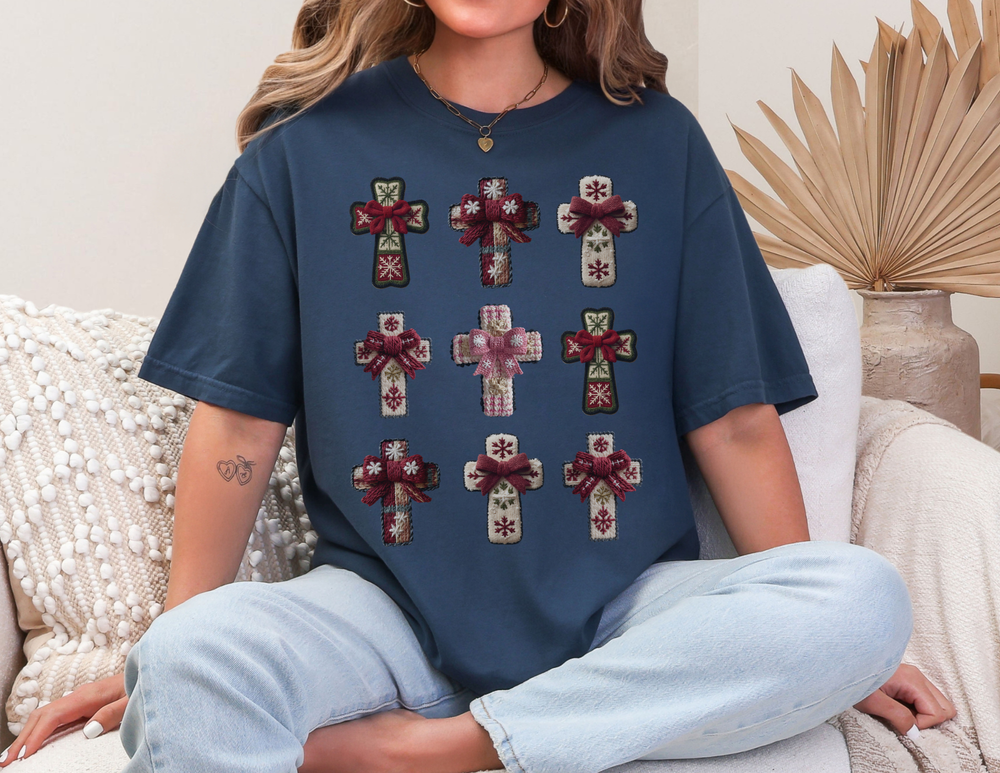 Person in navy Crosses Tee with decorative snowflake crosses sits on sofa, evoking cozy, relaxed vibe.