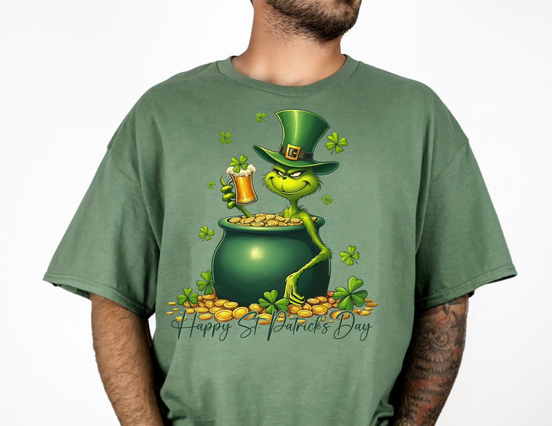 Grinchy St Patrick's Tee features a cartoon frog in a pot of gold on a green shirt, ideal for fans of quirky graphic t-shirts.