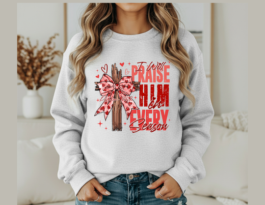 Praise in Every Season Heart Crew sweatshirt with wooden cross and pink ribbon design, emphasizing comfort with a polyester-cotton blend and ribbed collar for shape retention.