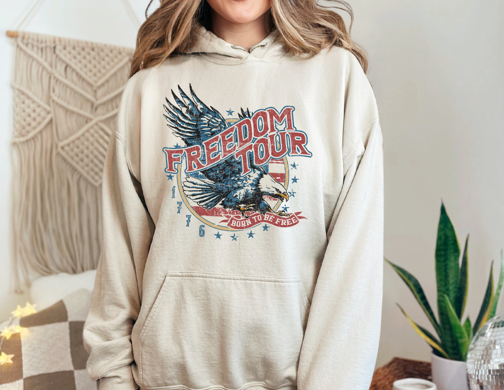 A classic Freedom Tour Hoodie, a unisex heavy blend hooded sweatshirt in cotton and polyester, featuring a kangaroo pocket and drawstring hood. Medium-heavy fabric for warmth and comfort. No side seams.