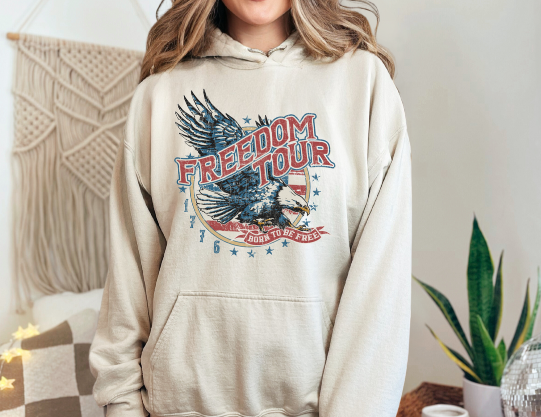 A classic Freedom Tour Hoodie, a unisex heavy blend hooded sweatshirt in cotton and polyester, featuring a kangaroo pocket and drawstring hood. Medium-heavy fabric for warmth and comfort. No side seams.