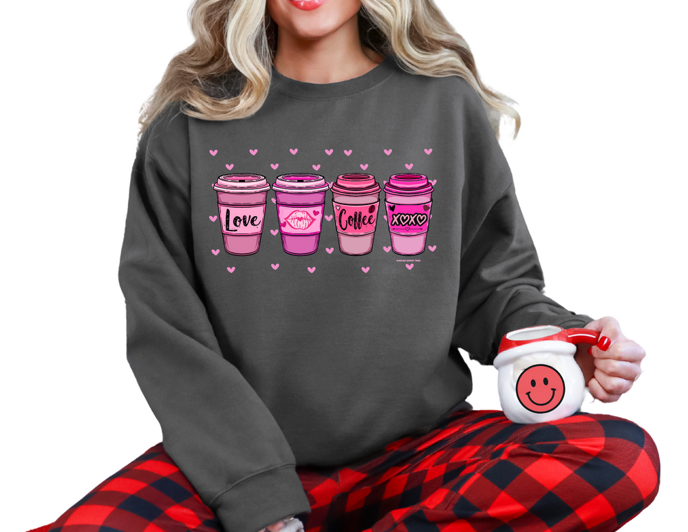 Woman in a cozy XOXO Coffee Crew sweatshirt, holding a pink mug, sitting comfortably, showcasing the sweatshirt's loose fit and comfort.