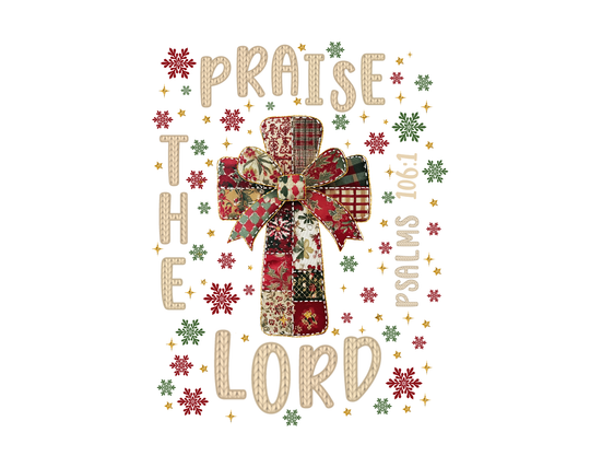 Praise the Lord Tee featuring a patchwork cross with festive ribbon, surrounded by snowflake and star motifs, and Psalms 106:1 scripture reference.