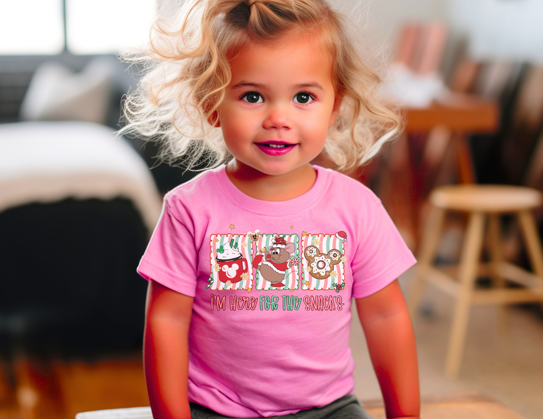 Toddler wearing the Here for the Snacks tee with snack illustrations, perfect for sensitive skin. Ideal for playtime in a living room setting.