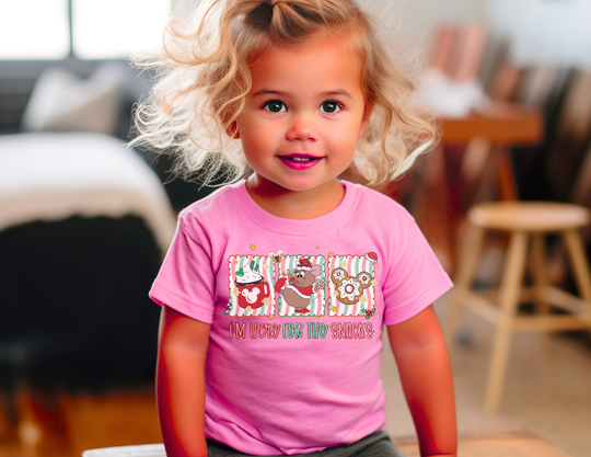 Toddler wearing the Here for the Snacks tee with snack illustrations, perfect for sensitive skin. Ideal for playtime in a living room setting.