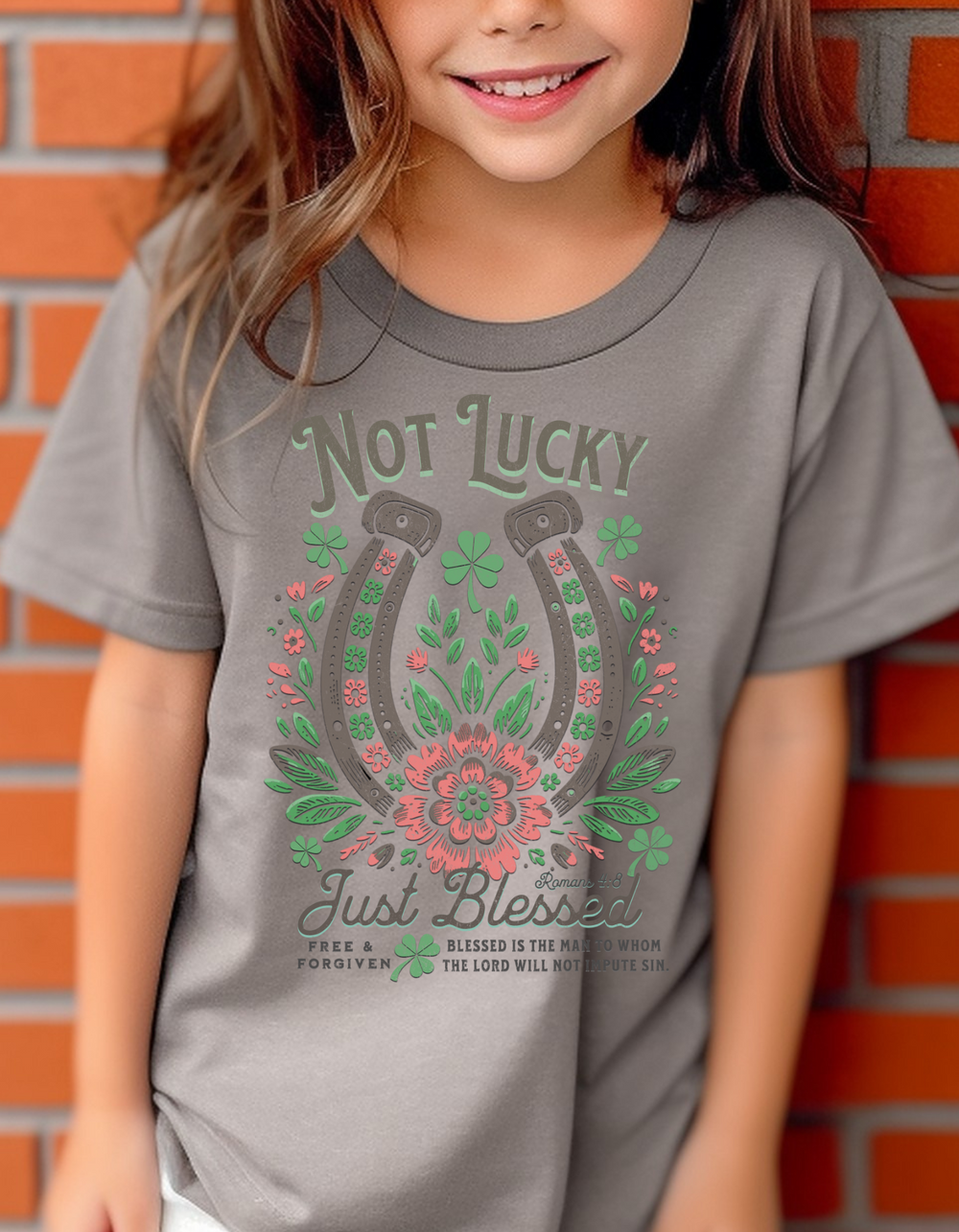 Girl wearing a Blessed Kids Tee in front of a brick wall, showcasing a comfortable, classic fit ideal for active kids, made from 100% combed ring-spun cotton.