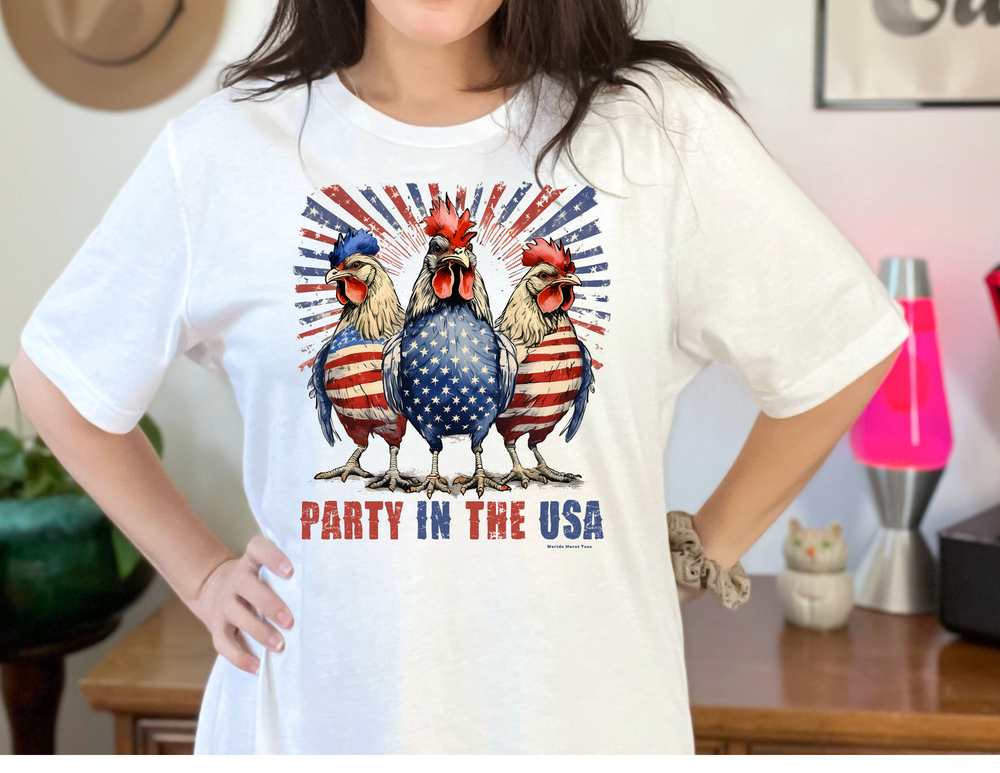 A white tee featuring a fun design of chickens and flags, embodying a patriotic vibe. Made of soft cotton, with ribbed knit collars and taping on shoulders for durability. From Worlds Worst Tees.