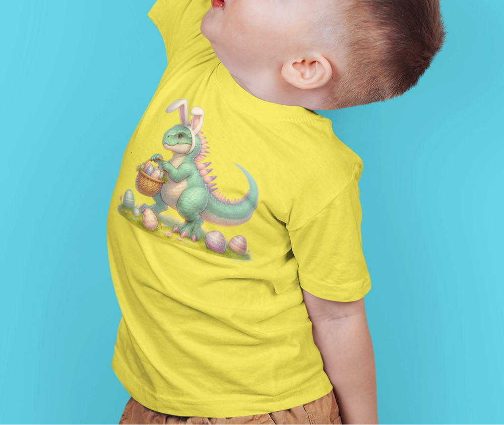 A child in a dinosaur tee raises his hand, showcasing the Eggosaurus Toddler Tee from Worlds Worst Tees. Soft, 100% cotton, with a durable print, perfect for sensitive skin. Sizes from 2T to 5-6T.