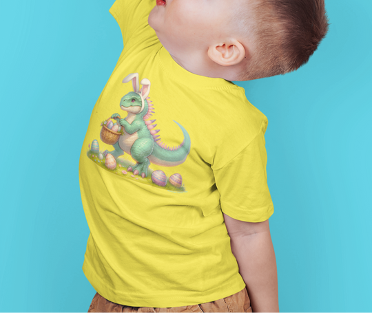 A child in a dinosaur tee raises his hand, showcasing the Eggosaurus Toddler Tee from Worlds Worst Tees. Soft, 100% cotton, with a durable print, perfect for sensitive skin. Sizes from 2T to 5-6T.