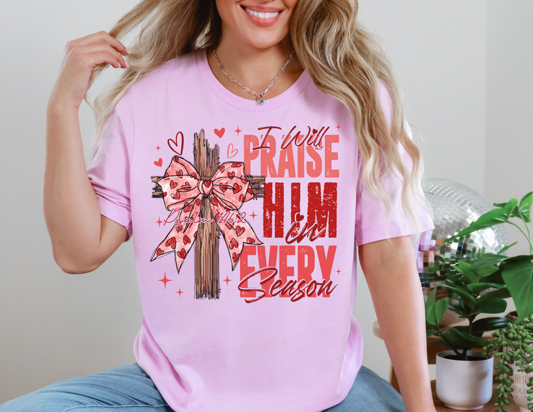 Praise in Every Season Heart Tee with wooden cross and bow graphic, surrounded by hearts and sparkles, showcasing Psalm 146:2. Classic unisex fit, soft cotton.