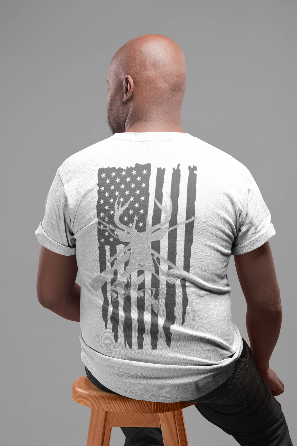 A man in a Real American Tee with a flag print, showcasing a high-quality, light fabric ideal for workouts or daily wear. 100% combed cotton, premium fit, tear-away label. Sizes XS to 4XL available.