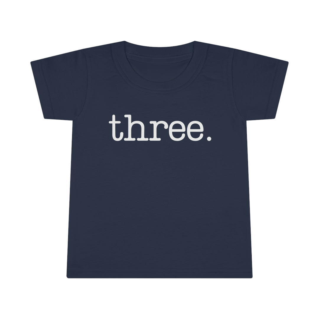 Three Toddler Tee, blue shirt with white text, close-up logo detail, 100% Ringspun cotton, classic fit, durable double-needle collar, sleeve, and bottom hems. Comfy and stylish for kids.