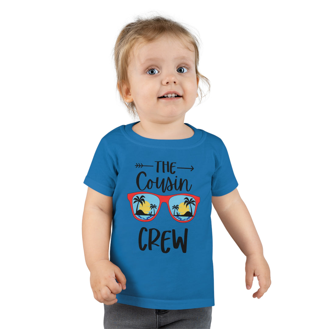 A personalized Cousin Crew Toddler Tee by Gildan 64500P, featuring a child in a blue shirt. Classic fit, high stitch density, 3/4 double-needle collar, and durable hems. Ideal for kids' comfort and style.
