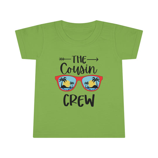A personalized Cousin Crew Toddler Tee with a beach and palm tree graphic on a green shirt. Classic fit, high stitch density, and durable construction for comfort and style. Ideal for kids.