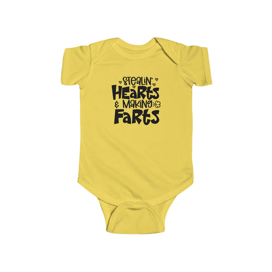 A yellow baby bodysuit with black text, featuring the Stealin Hearts and Making Farts design. Made of 100% cotton, with ribbed bindings and plastic snaps for easy changing. From Worlds Worst Tees.