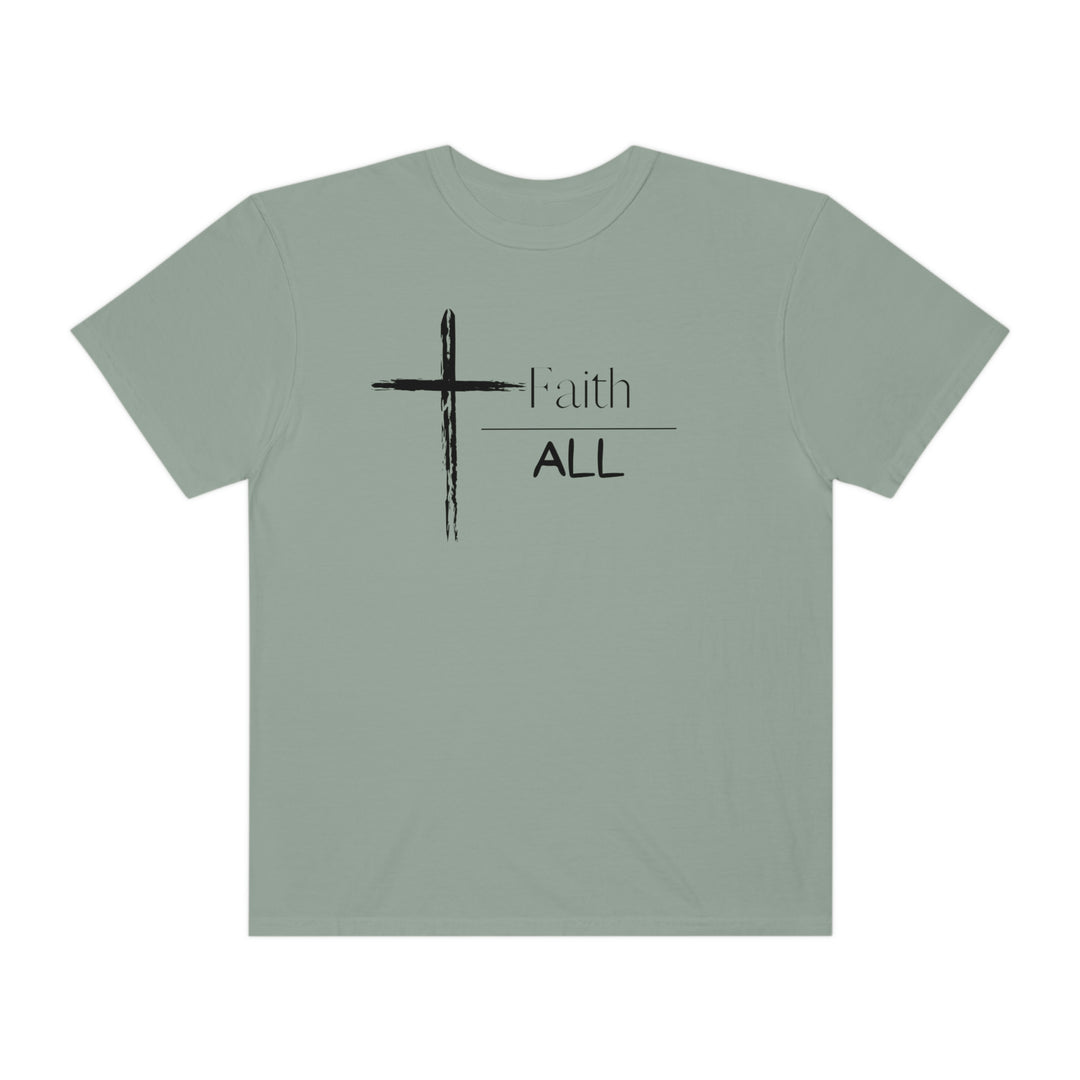 A Faith Over All Tee, a garment-dyed t-shirt with a cross and text design. Made of 100% ring-spun cotton, featuring a relaxed fit and double-needle stitching for durability.