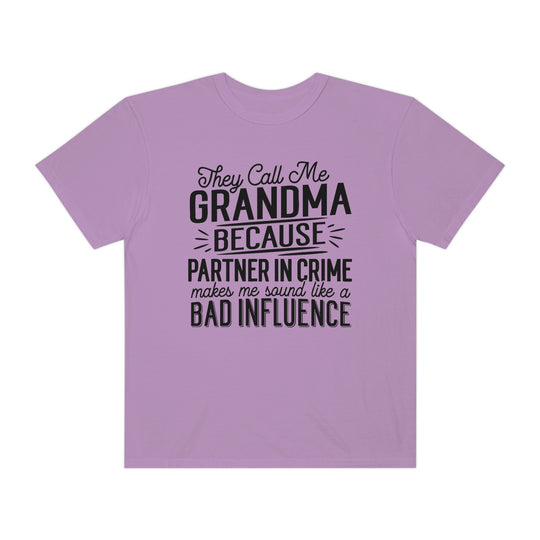 Relaxed fit They Call Me Grandma Tee, a purple shirt with black text. 100% ring-spun cotton, garment-dyed for coziness. Durable double-needle stitching, tubular shape. Ideal for daily wear.