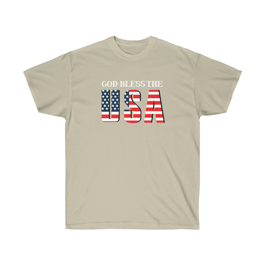 Unisex God Bless The USA Dudes Tee, featuring patriotic red, white, and blue text on a tan t-shirt. Classic fit, sustainably sourced cotton, tear-away label. Ideal for a standout, comfortable look.