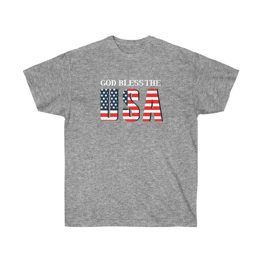 Unisex God Bless The USA Dudes Tee, a classic cotton shirt with patriotic red, white, and blue text. Features include shoulder taping, no side seams, ribbed collar, sustainably sourced materials.