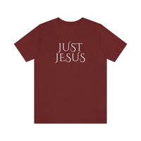 A beloved Just Jesus Tee in red with white text. Unisex jersey tee with ribbed knit collar, shoulder taping, and side seams for lasting shape. Made of 100% Airlume combed cotton.