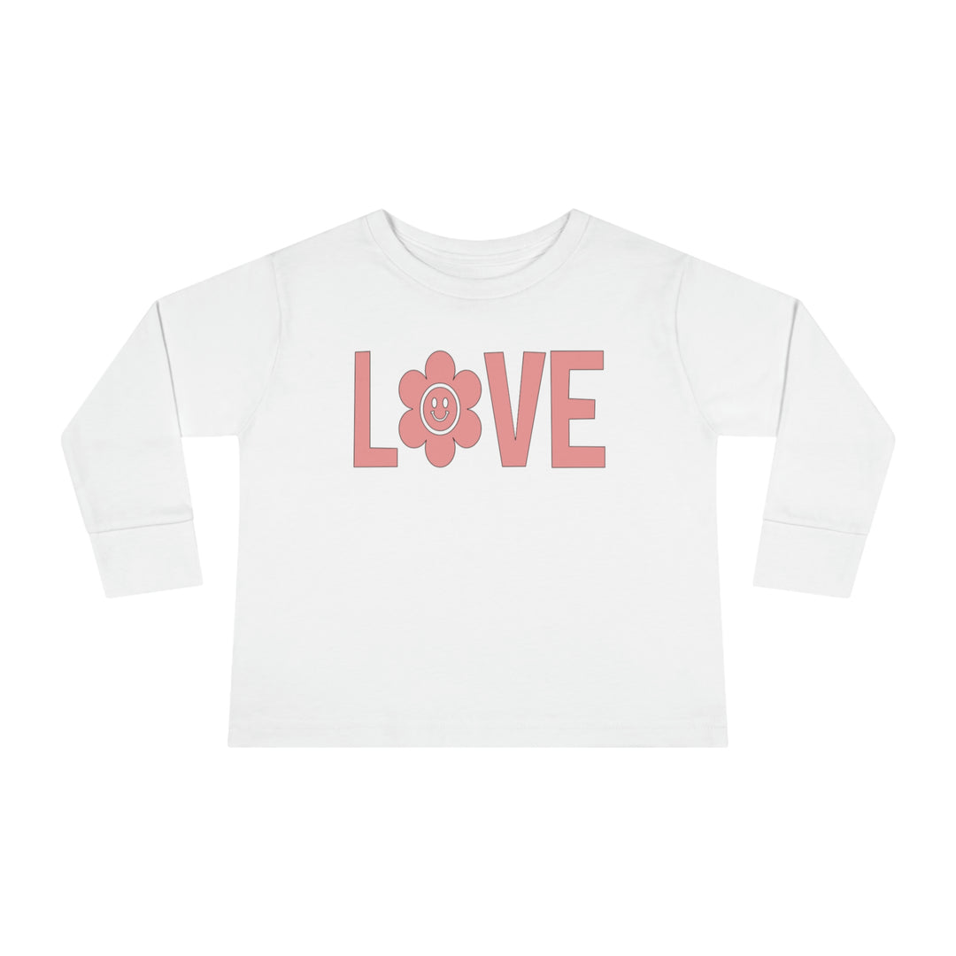 A Love Toddler Long Sleeve Tee crafted from 100% cotton, featuring pink lettering and a flower design. Perfect for active kids with a durable ribbed collar and shoulder-to-shoulder taping for comfort.