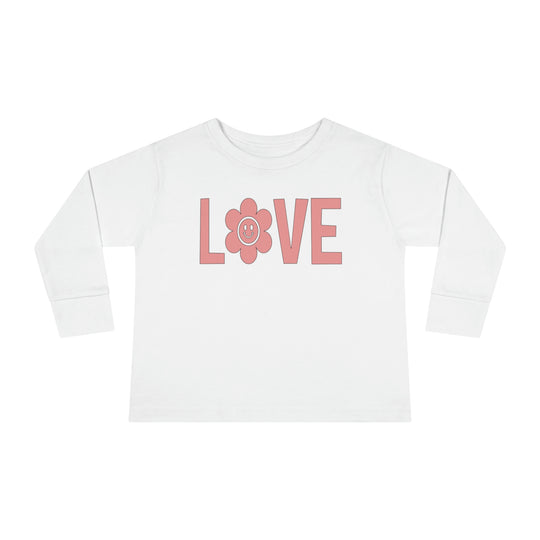A Love Toddler Long Sleeve Tee crafted from 100% cotton, featuring pink lettering and a flower design. Perfect for active kids with a durable ribbed collar and shoulder-to-shoulder taping for comfort.