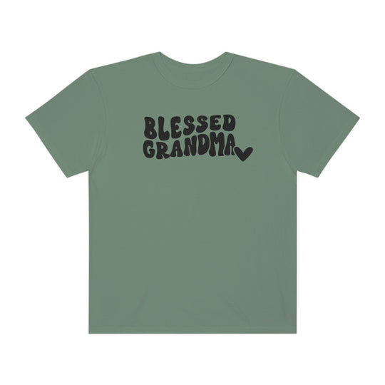 A Blessed Grandma Tee, a garment-dyed t-shirt in green with black text. Made of 100% ring-spun cotton, featuring a relaxed fit for daily comfort. Durable double-needle stitching, no side-seams for shape retention.