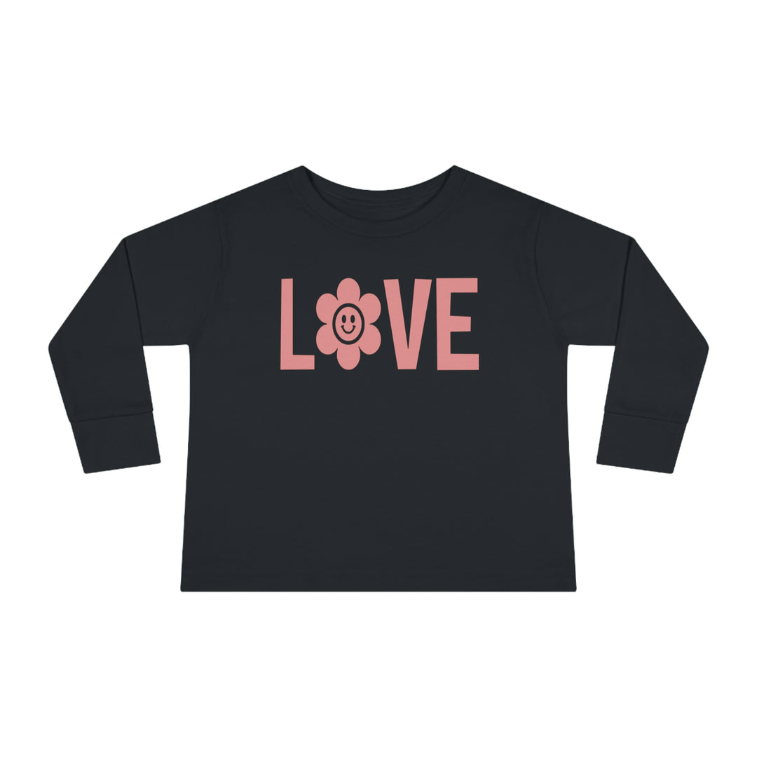 Love Toddler Long Sleeve Tee featuring a black shirt with pink letters, a flower, and a smiley face. Made of durable 100% combed ringspun cotton, with topstitched ribbed collar for comfort. Toddler unisex fit.
