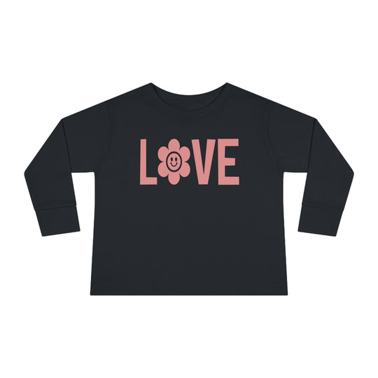 Love Toddler Long Sleeve Tee featuring a black shirt with pink letters, a flower, and a smiley face. Made of durable 100% combed ringspun cotton, with topstitched ribbed collar for comfort. Toddler unisex fit.