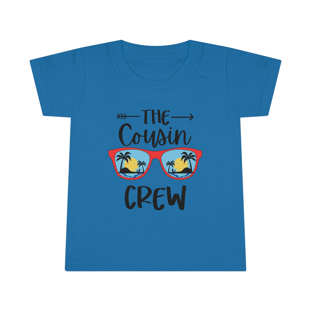 Toddler tee featuring Cousin Crew design on blue shirt with sunglasses-wearing person, beach, palm trees. Classic fit, high stitch density, double-needle collar, sleeve, bottom hems for durability. Ideal for kids.