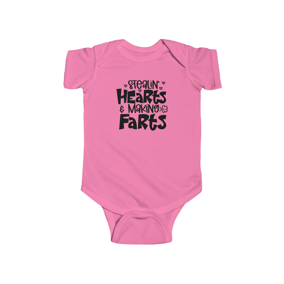 A pink baby bodysuit with black text, featuring the playful title Stealin Hearts and Making Farts Onesie. Made of 100% cotton, with ribbed knitting for durability and plastic snaps for easy changing access. From Worlds Worst Tees.