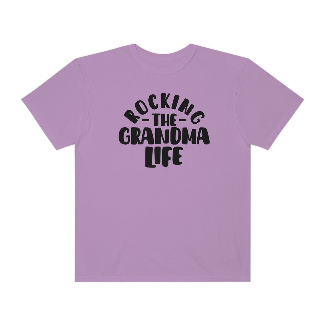 Rocking the Grandma Life Tee: A purple shirt with black text, 100% ring-spun cotton, medium weight, relaxed fit, double-needle stitching, no side-seams, cozy and durable.