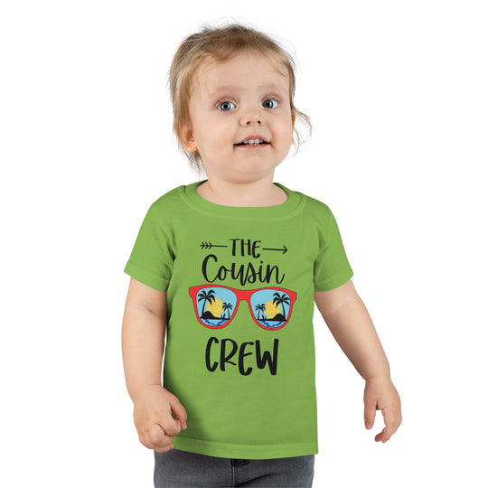 A Cousin Crew Toddler Tee by Worlds Worst Tees, featuring a child in a green shirt. Personalized toddler t-shirt with a classic fit, high stitch density, and durable double-needle collar and hems.