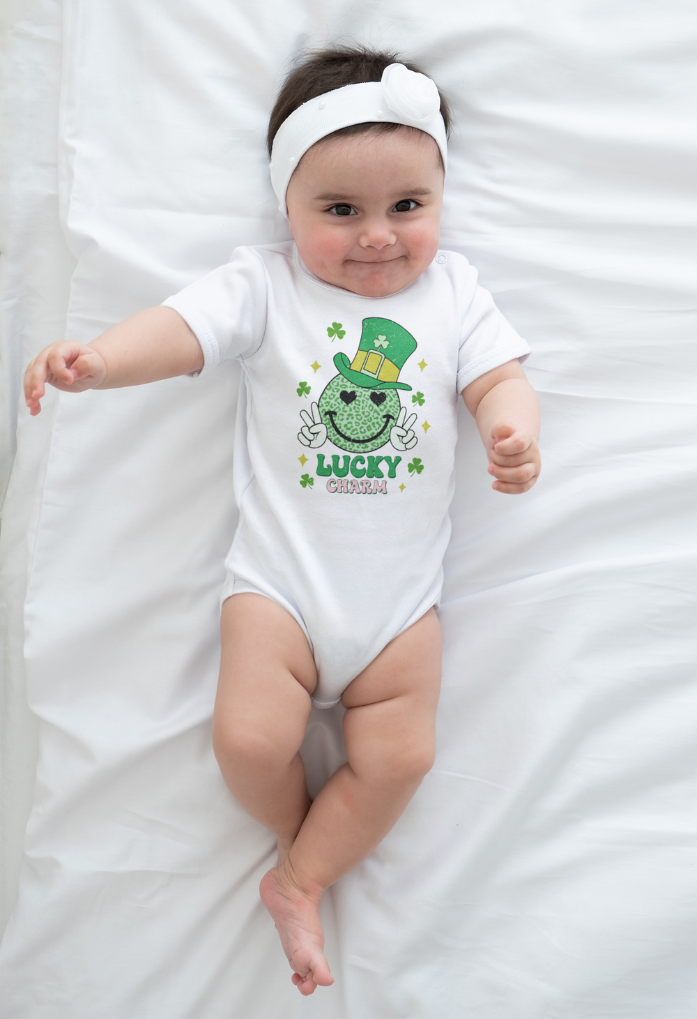 A Little Charm Onesie for infants, featuring a green and white smiley face design with a hat. Made of 100% cotton, with ribbed bindings and plastic snaps for easy changes. Ideal for 0-24M.